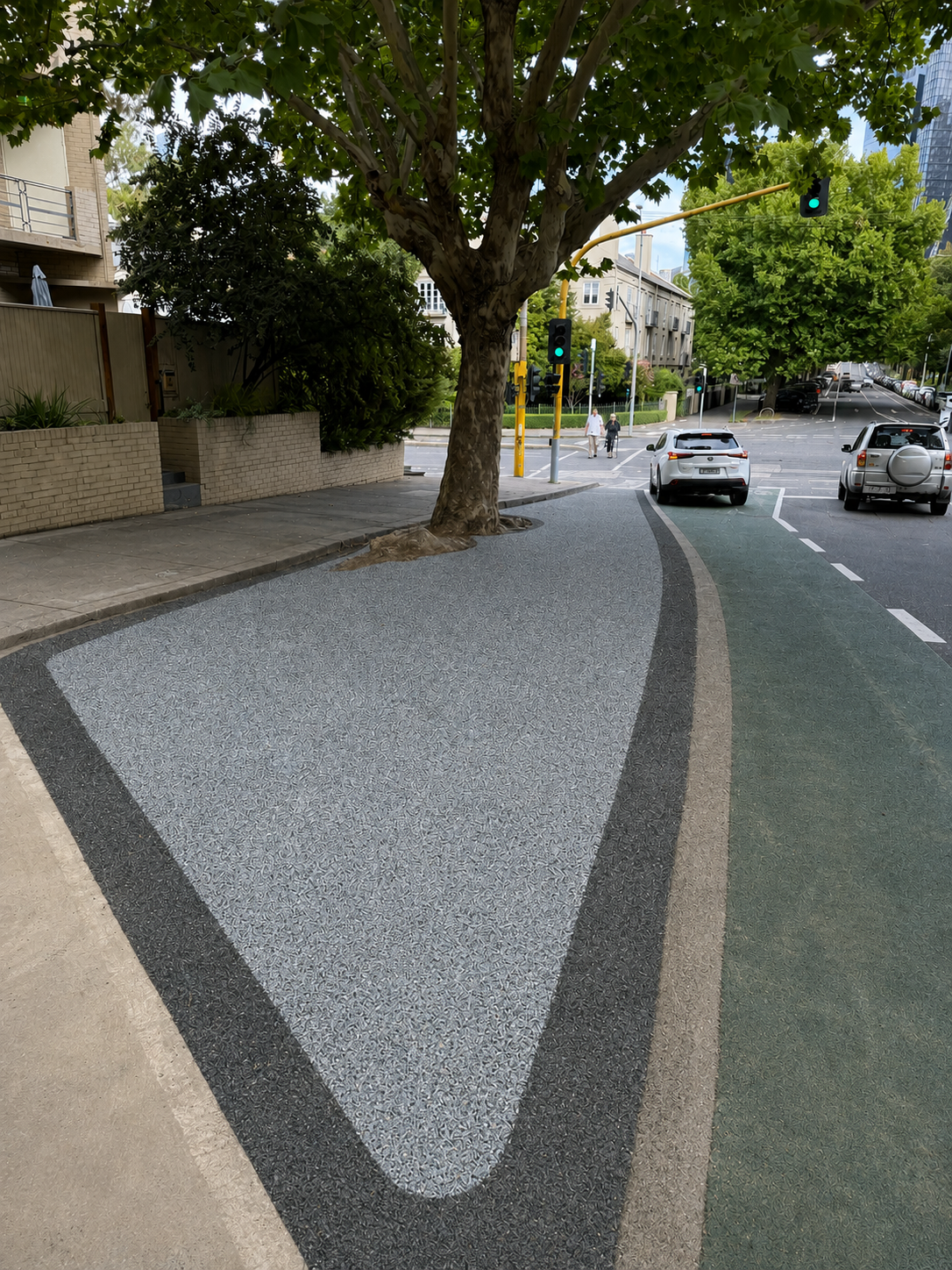 Street tree pit installed in permeable paving in grey and charcoal, sitting between footpath and roadway.